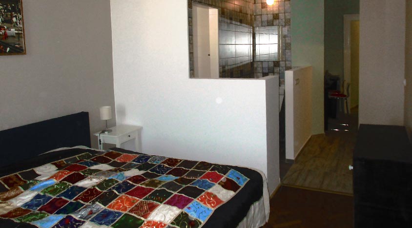 Schlafzimmer und Blick auf das Badezimmer des Buda Apartment